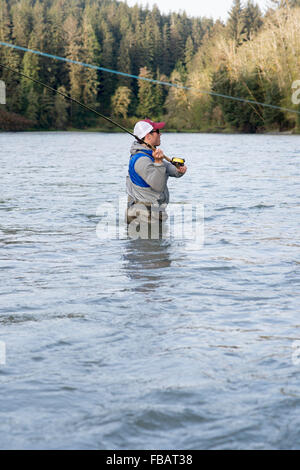 Maschio di pescatore di Pesca a Mosca Report di Pesca in un fiume sulla Penisola Olimpica nello Stato di Washington Foto Stock