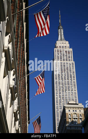 Empire State Building & noi tre bandiere che sventolano nel cielo blu chiaro, New York Manhattan, STATI UNITI D'AMERICA Foto Stock
