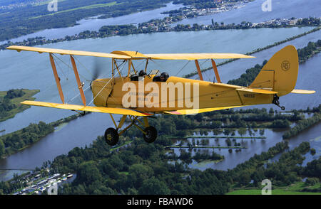 Un de Havilland Tiger Moth bi-piano oltre la campagna Olandese Foto Stock