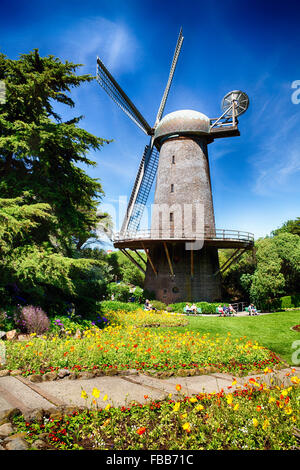 Basso angolo vista del mulino a vento olandese con la fioritura di tulipani e papaveri, Golden Gate Park di San Francisco, California Foto Stock