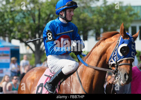 Vista ravvicinata di un fantino seduto sul cavallo ottenere pronto per una corsa di cavalli. Monmouth Park Recetrack, Oceanport, New Jersey Foto Stock