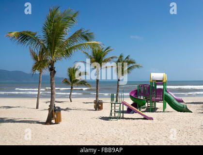 Un colorato parco giochi su una spiaggia deserta di Da Nang, Vietnam. Sullo sfondo sono belle montagne. Foto Stock