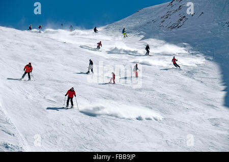 Gli sciatori fanno il loro cammino verso il basso la Super Diable pista nera sopra il francese località sciistica di Les Deux Alpes, l'Europa. Foto Stock