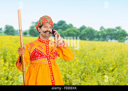 1 rurale indiano Gujrati abitante fattoria parlante permanente di telefono mobile Foto Stock