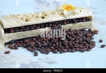 Chicchi di caffè tostati spillar fuori della scatola. Foto Stock