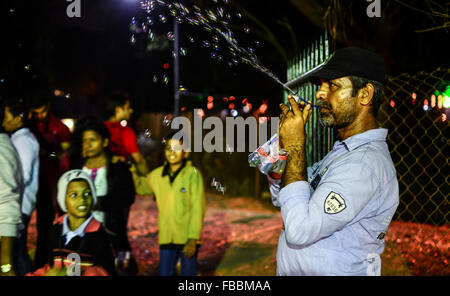 Un disoccupato di Indian soap bubble machine venditore soffiando bolle di sapone in aria per attirare i bambini a IFFI Venue, Panjim, Goa Foto Stock