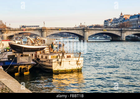 Senna con chiatte e giovane sulla terrazza sulla barca, Pont de la Concorde, ponte dietro, Parigi Francia. Foto Stock