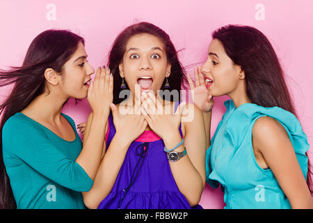 3 giovani indiani Womans amici Whisper parlando Foto Stock