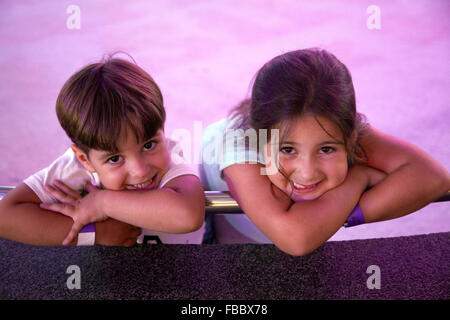 Due giovani fratelli sorriso in appoggio sul parapetto Foto Stock