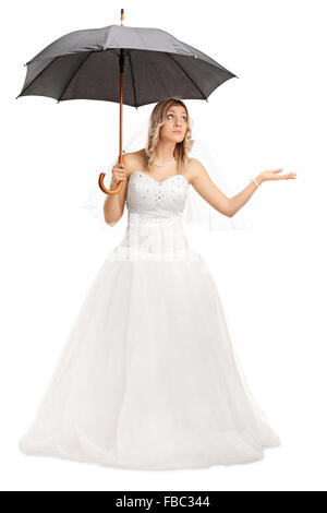 A piena lunghezza Ritratto di una giovane sposa in bianco di un abito da sposa con ombrello isolati su sfondo bianco Foto Stock