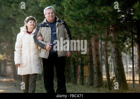Coppia senior camminare insieme in posizione di parcheggio Foto Stock