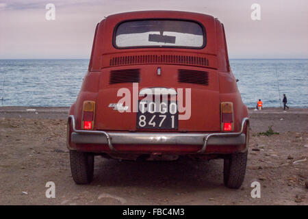 Un rosso 500 Fiat Cinquecento parcheggiata sulla spiaggia vicino a Taormina in Sicilia. Foto Stock