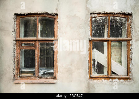 Sullo sfondo di un vecchio stucco bianco parete con due finestre in legno con macchie di vernice dopo la ristrutturazione, pezzi di architettura, retro hou Foto Stock