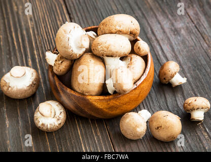 Fresca bruna funghi champignon in ciotola di legno Foto Stock