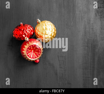 Rosso di festa e di Natale Golden Globes su nero lo sfondo di legno Foto Stock