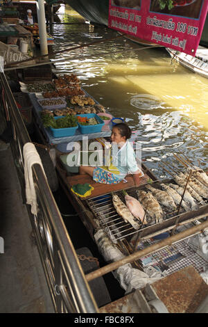 Giovane donna su una chiatta la vendita di pesce e frutti di mare, taling chan mercato galleggiante, chak phra, bangkok, Thailandia, in Asia. Foto Stock