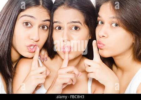 3 indian giovane e bella Womans amici dito in bocca il silenzio Foto Stock