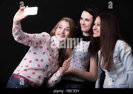 Gruppo di belle ragazze ridono, tenendo selfie, autoritratto con telefono cellulare, migliori amici sorridenti insieme, ha Foto Stock