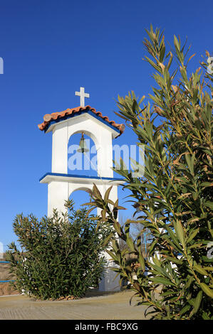 Il campanile di San Nicola (AGIOS NIKOLAOS) cappella circondata da Daphne oleandro arbusto. Kotsinas quay. Lemnos Island, Grecia. Foto Stock