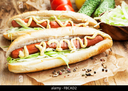 Pasto Hot-Dog.salsicce con ciambelle di pane, lattuga, senape e ketchup salse Foto Stock