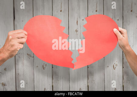 Immagine composita della coppia ritagliata mani red incrinato forma di cuore Foto Stock
