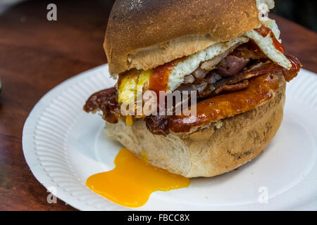 Un riempito Belfast Bap con salsicce, uova e pancetta servita nel tradizionale di San Giorgio e mercato. Foto Stock