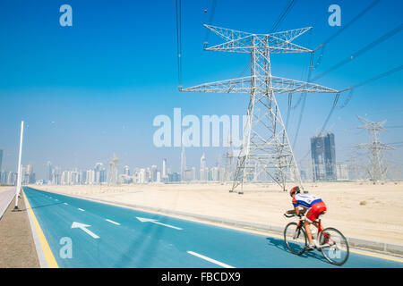 Ciclista sulla nuova pista ciclabile a distretto uno in corrispondenza di nuovo lo sviluppo di proprietà in Dubai Emirati Arabi Uniti Foto Stock