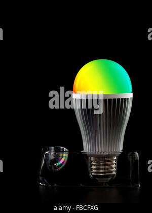 Colore LED lampadina camaleonte su un supporto isolato su nero Foto Stock