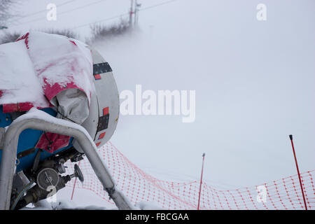 Close up di un inverno Neve macchina per la produzione di neve artificiale per contribuire a coprire le piste da sci in una località di montagna Foto Stock