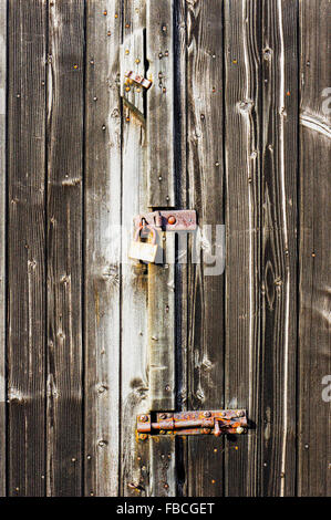 Parte di un fienile porta bloccata e imbullonati con weathered di pannelli di legno Foto Stock