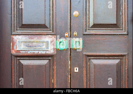 Un weathered porta di legno con un arrugginito letterbox Foto Stock