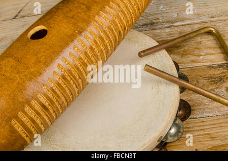 Tradizionale piccola p'ercussion strumenti in una vita ancora su un rustico di una superficie di legno Foto Stock