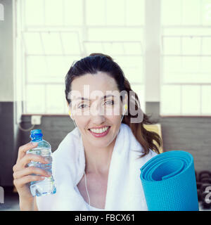 Immagine composita di montare la bella bruna guardando la fotocamera mentre si ascolta la musica Foto Stock