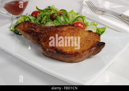 Fried bistecca con l'osso con verdure e ketchup Foto Stock