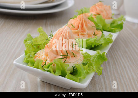 Uova ripiene di pâté di salmone in foglie di lattuga Foto Stock