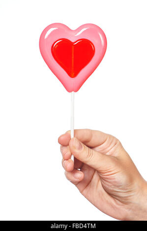 Mano azienda lecca-lecca a forma di cuore Foto Stock