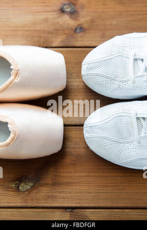 Close up sneakers e pointe shoes su legno Foto Stock