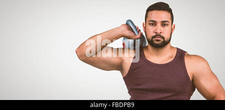 Immagine composita di muscolare uomo gravi tenendo un kettlebell Foto Stock