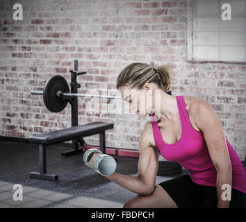 Immagine composita della donna muscolare esercizio con manubri Foto Stock