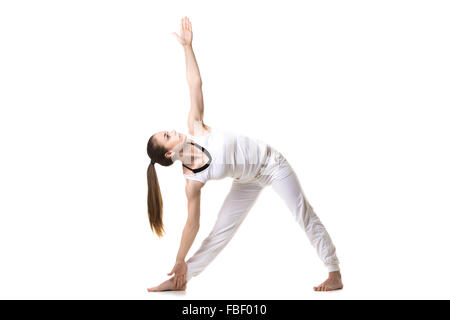 Bellissimo modello fitness le pratiche yoga o pilates, in piedi nel triangolo Yoga asana Trikonasana, stretching esercizio, vista frontale Foto Stock