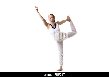 Bellissimo modello fitness le pratiche yoga o pilates, in piedi Natarajasana, Shiva ballando pongono, tre quarti vista, studio sho Foto Stock