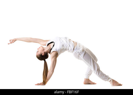 Giovani modello di fitness in bianco sportswear fare yoga o pilates formazione, esercizio bridge, asana Camatkarasana, Wild Thing, Dancin Foto Stock