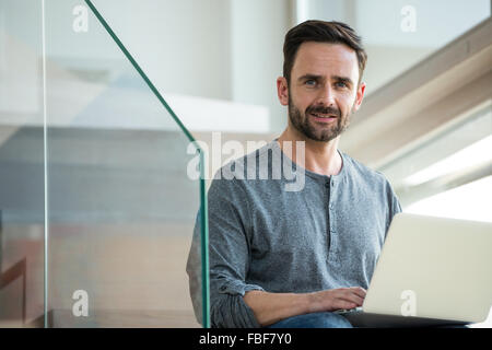 Uomo con notebook in scale Foto Stock