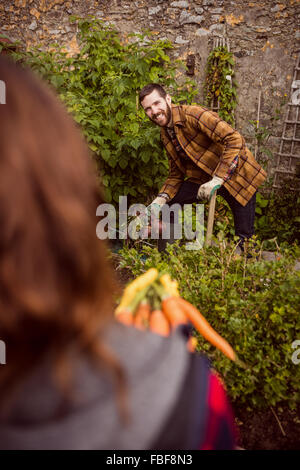 Coppia giovane azienda barbabietole e carote Foto Stock