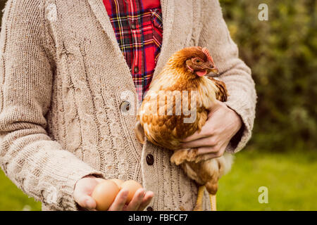 Uomo con pollo e uovo Foto Stock