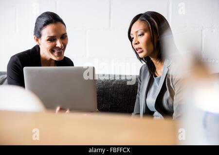 Imprenditrici utilizzando laptop sul lettino Foto Stock