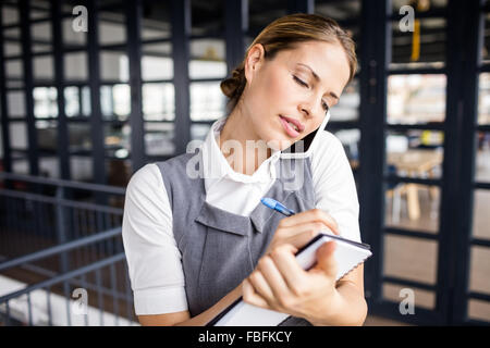 Ritratto di un sorridente imprenditrice avente una chiamata telefonica Foto Stock