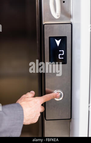 Vista ravvicinata di imprenditore premendo il pulsante di elevatori Foto Stock