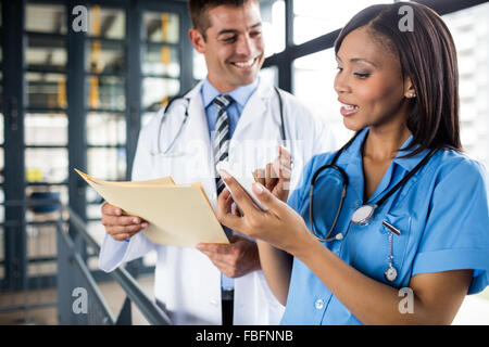 Infermiera e medico guardando un telefono Foto Stock