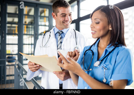 Infermiera e medico guardando un telefono Foto Stock